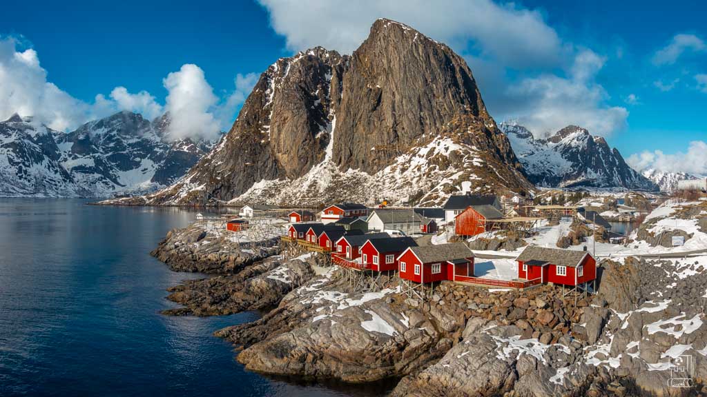 Classic red Norwegian cabins on stilts over the water in Lofoten, offering an authentic and charming stay in the heart of the islands.
