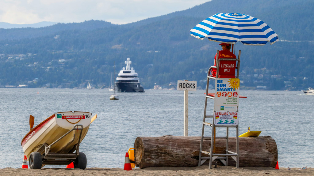 Kitsilano Beach lifeguard station with mountains in background highlighting beach neighborhood accommodations in Vancouver